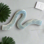 A stylish hair accessory featuring a unique wave-shaped design, perfect for securing updos with elegance. Crafted with a light blue finish, it adds a chic touch to any outfit. Ideal for medium to thick hair. 
