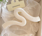 A stylish hair accessory featuring a unique wave-shaped design, perfect for securing updos with elegance. Crafted with a light blue finish, it adds a chic touch to any outfit. Ideal for medium to thick hair. 